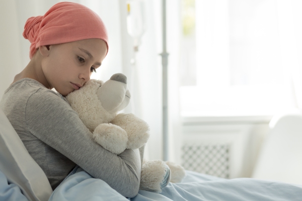 young girl with cancer hugging a bear