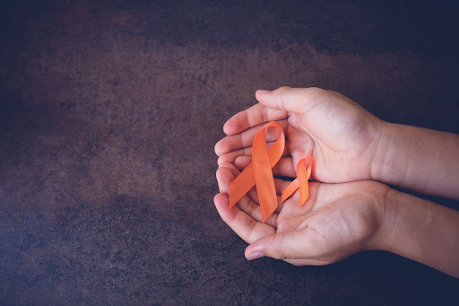 hands holding orange ribbons